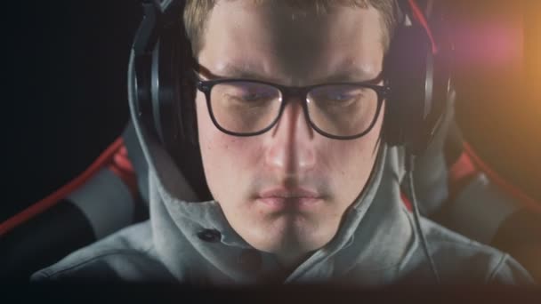 Mannelijke gamer in bril kijkt naar een monitor, close-up. — Stockvideo