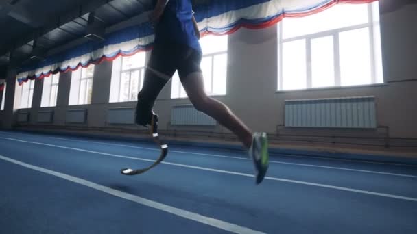 Um homem correndo com perna protética, vista lateral . — Vídeo de Stock