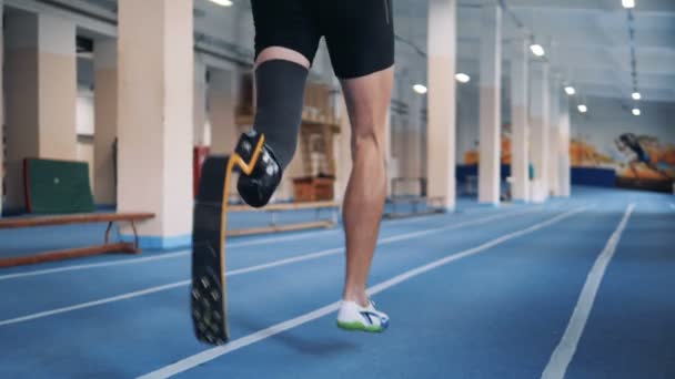 Disabled runner with bionic prosthesis, back view. — Stock Video