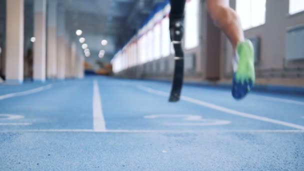 Pessoa com prótese biônica correndo em uma faixa especial, visão traseira . — Vídeo de Stock