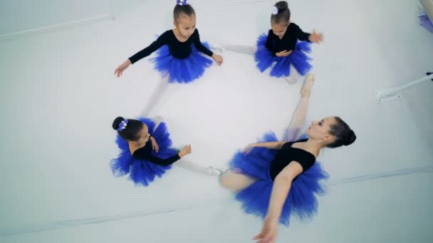 Kislány és a balett-tanár nyújtás, ülve — Stock videók