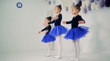 Üç küçük kız bale egzersizleri yapıyor