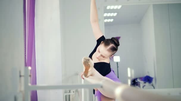 Dama bailarina se estira cerca de la barra en un estudio de ballet — Vídeos de Stock