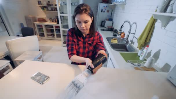 Young lady is putting on a prosthetic hand and moving it — Stock Video