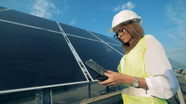 Frau tippt auf Tablet, während sie in der Nähe von Sonnenkollektoren arbeitet, Nahaufnahme. — Stockvideo