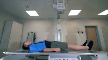 Onu yan görünüm tarama tomografik makine yatan adam.