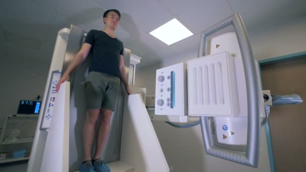 Een persoon met behulp van verticale tomografie machine, close-up. — Stockvideo