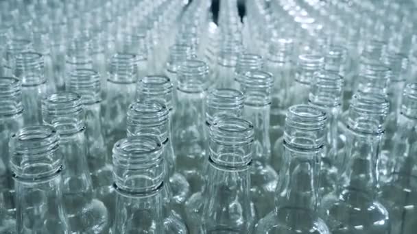 Cuellos de botellas de vidrio en movimiento en un primer plano — Vídeos de Stock