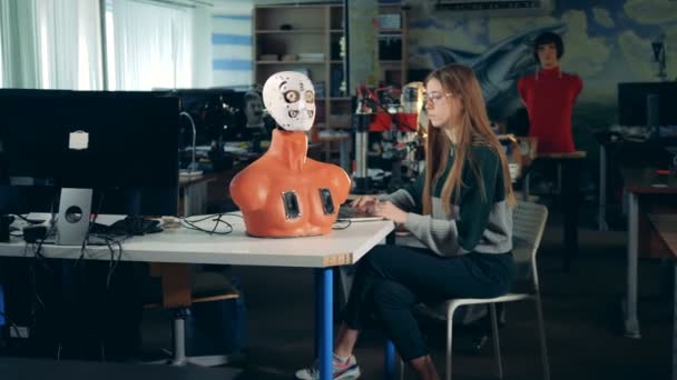 En flicka fungerar med android, nära. Robotliknande android vid ingenjör lab. — Stockvideo