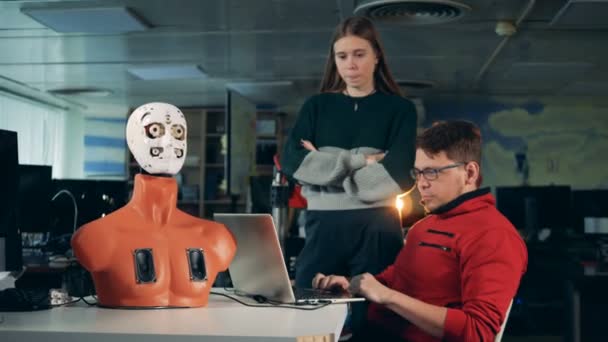 Ingegneri che controllano un droide, usando un computer portatile, da vicino . — Video Stock