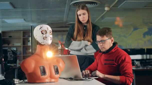 Férfi és a nő egy szobában bionikus robot dolgozik, közelről. — Stock videók