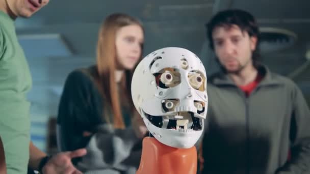 男人和女人说话, 检查机器人的头, 关闭. — 图库视频影像