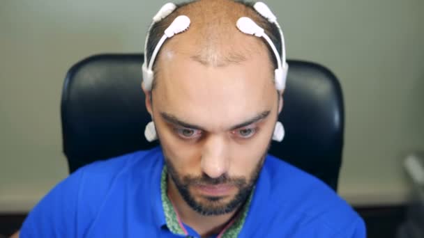 Man dragen robotic Brainwave scannen sensoren op zijn hoofd, close-up. — Stockvideo