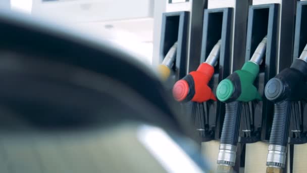 Gas pump with multiple nozzles inserted into it — Stock Video
