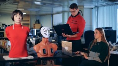 İşçiler dizüstü bilgisayarlar kullanarak robotlar kontrol, yakın çekim.