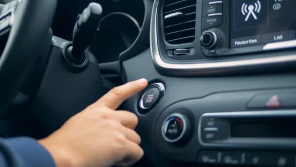 Мужская рука запускает и останавливает двигатель автомобиля нажатием кнопки — стоковое видео