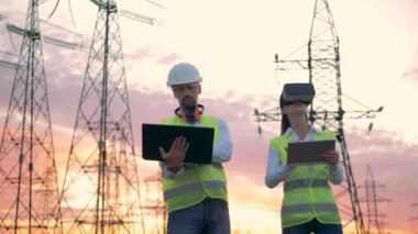 İki uzman bilgisayarlarını elektrik hatları yakınında dururken faaliyet gösteriyor. Endüstriyel kullanımdaki sanal gerçeklik.