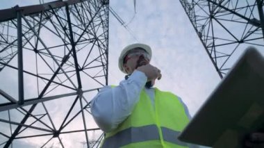 Erkek teknisyen elektrik towers olurken bir bilgisayar tarama