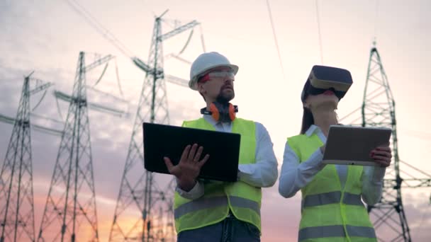 Žena v Vr brýle a člověk jsou v provozu počítače poblíž Etl — Stock video