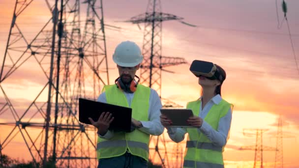 Outdoors ETL with two technicians working with computers using VR headset. — Stock Video