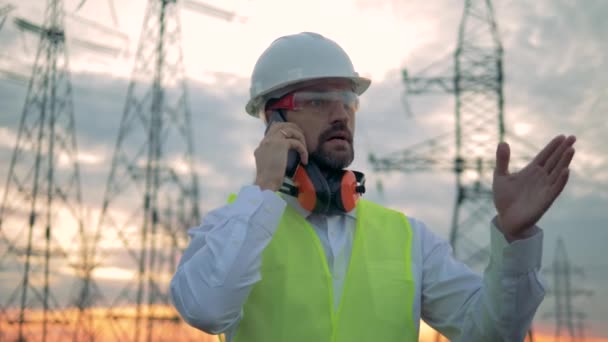 Anruf eines männlichen Spezialisten, der neben Stromleitungen steht — Stockvideo