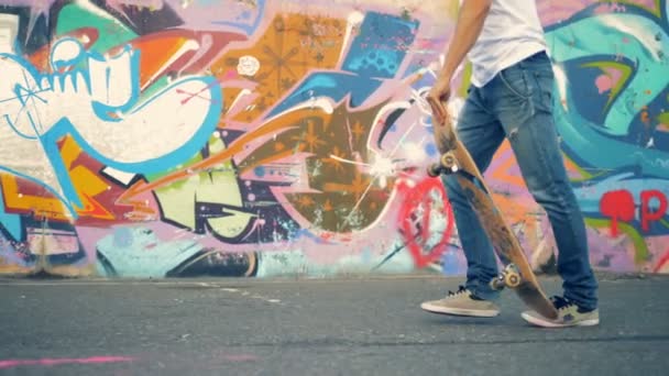 Мужчина всадник встает на скейтборд и начинает двигаться — стоковое видео