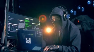 Kapüşonlu erkek hacker bilgisayar çalışıyor. 4k