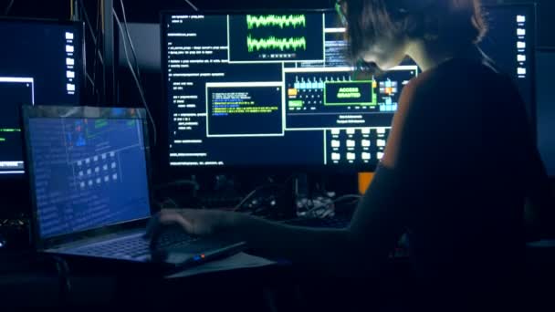 Computadoras portátiles y ordenadores están siendo utilizados por una mujer joven para hackear — Vídeos de Stock