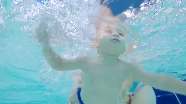 Einem Kind wird das Schwimmen beigebracht, gefilmt unter Wasser — Stockvideo