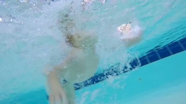 Menino está nadando debaixo d 'água sob a supervisão de suas mães — Vídeo de Stock