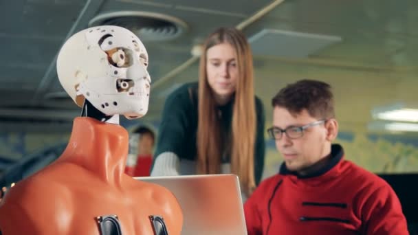 Robot est fait pour cligner des yeux par un homme et une femme spécialistes au moyen d'un ordinateur — Video