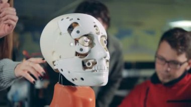 Bir robot yüz arka planda konuşma uzmanları ile ayrıntılı görünüm