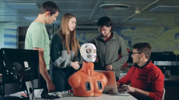 Команда инженеров обсуждает робота, похожего на человека — стоковое видео
