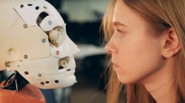 Genç kadın bir cyborg baş hareketleri yakından gözlemleyerek 