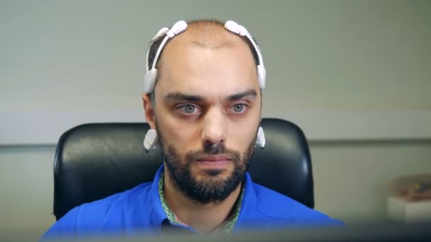 Frontansicht eines Mannes mit einem Bio-Signal-eeg-Headset — Stockvideo