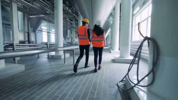 Two workers are walking along the brewery unit — Stock Video