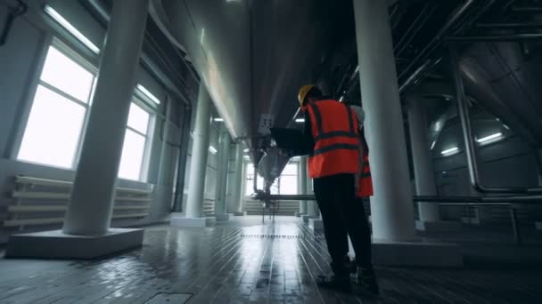 Een mannelijke en een vrouwelijke ingenieurs zijn observatie van een distilleerderij faciliteit — Stockvideo