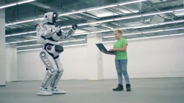 Genç çocuk bir robot ile onun laptop kullanıyor
