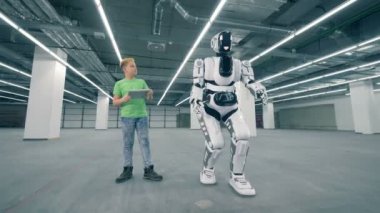 İnsan benzeri robot bir tablet ile bir çocuk tarafından yönlendirilen süre hareket ediyor