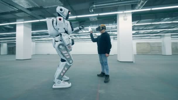 Мальчик в VR-очках и робот двигают рукой. — стоковое видео