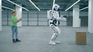 Biyonik droid bir genç çocuk gözetimi altında bir kutu taşıyan kaldırma