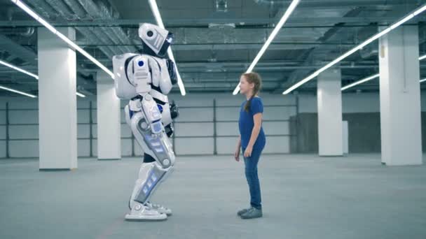 Een meisje en een robot raken palmen van elkaar — Stockvideo