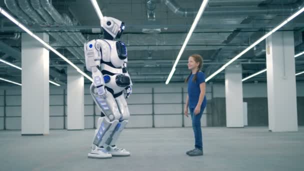 Mensachtige robot is een high-vijf geven aan een klein meisje — Stockvideo