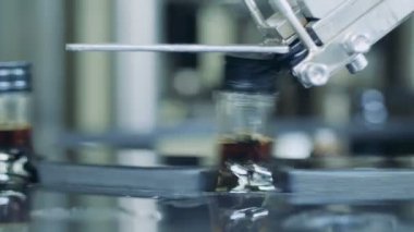 Fabrika ekipmanları işleri, şişe, kapaklar koyarak yakın çekim.