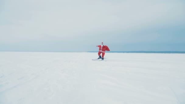 一个圣诞老人带着一个带礼物的袋子滑雪, 近距离. — 图库视频影像