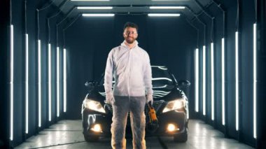 Gülümseyen bir adam bir buffwheel olan bir araba yakın duruyor