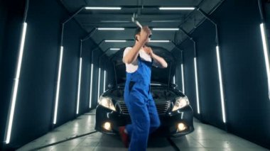 Mekanik bir araba yakınındaki onun elinde araçları ile dans ediyor. 4k