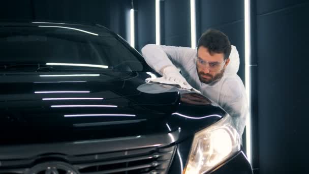 Automobile is getting polished with a cloth by a serviceman — Stock Video