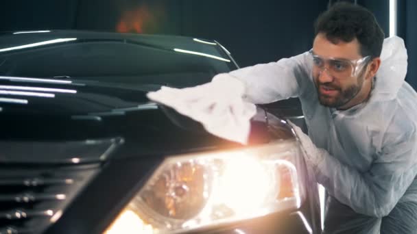 Cars surface is getting cleaned by an employee with a cloth — Stock Video