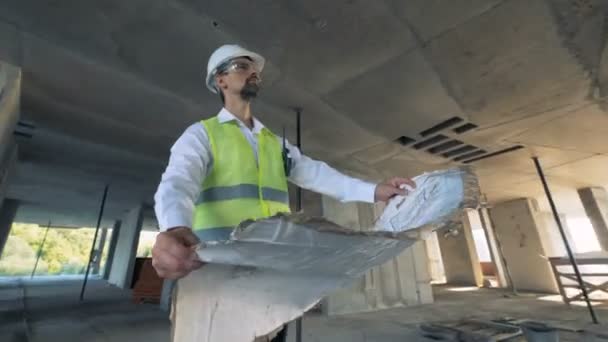 Ingenjören ser på en byggnad blåkopia, närbild. — Stockvideo